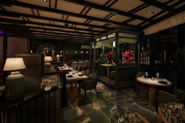 Elegant restaurant interior with dim lighting, cozy seating, dark wooden accents, and a sophisticated ambiance.