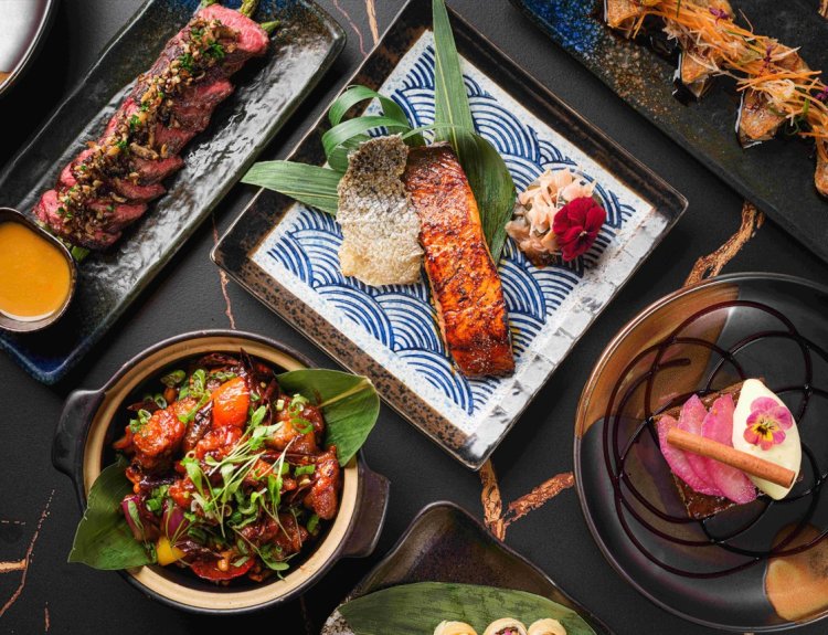 An overhead view of an elegant Japanese meal, perfect to celebrate your graduation with Tattu's "Wisdom of the Dragon" menu. Enjoy artistically arranged dishes and a unique experience with a complimentary glass of Champagne.